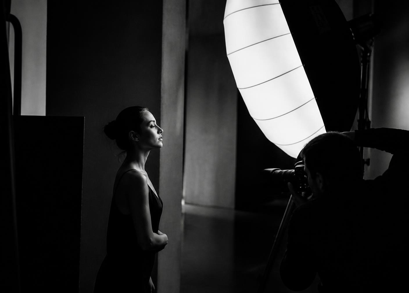 A portrait subject photographed under a large studio light